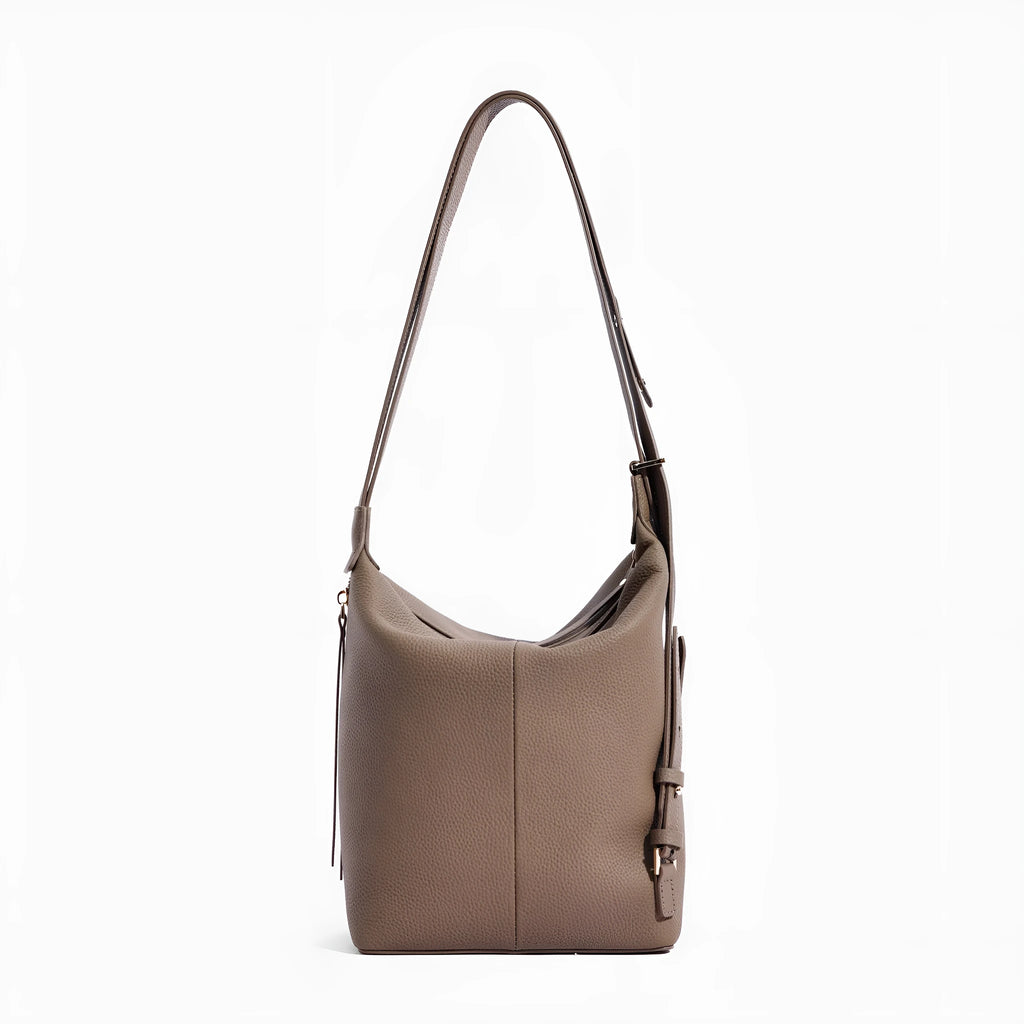 Women's large grey genuine leather bucket bag with a soft handle on a casual outfit.