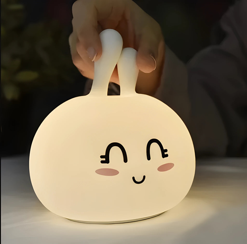 White marshmallow bunny LED night light with shy face or happy face option on a table.