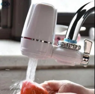 White plastic faucet water filter unit with adapters and ceramic cartridge for kitchen tap installation.