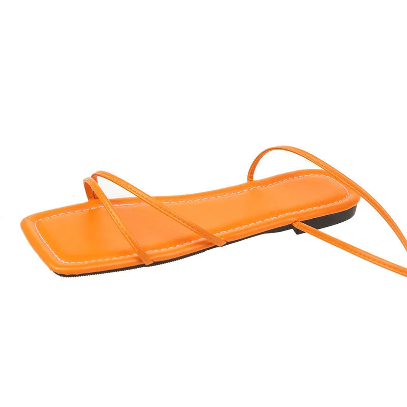 Women's flat sandals with ankle bandage straps and front lace-up in white, black, or orange.