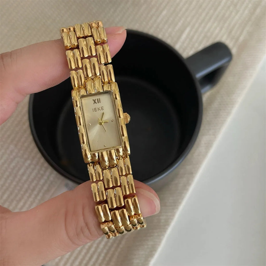 Women's silver and gold bracelet-style watch with a small 15mm dial and butterfly clasp.