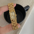 Women's silver and gold bracelet-style watch with a small 15mm dial and butterfly clasp.