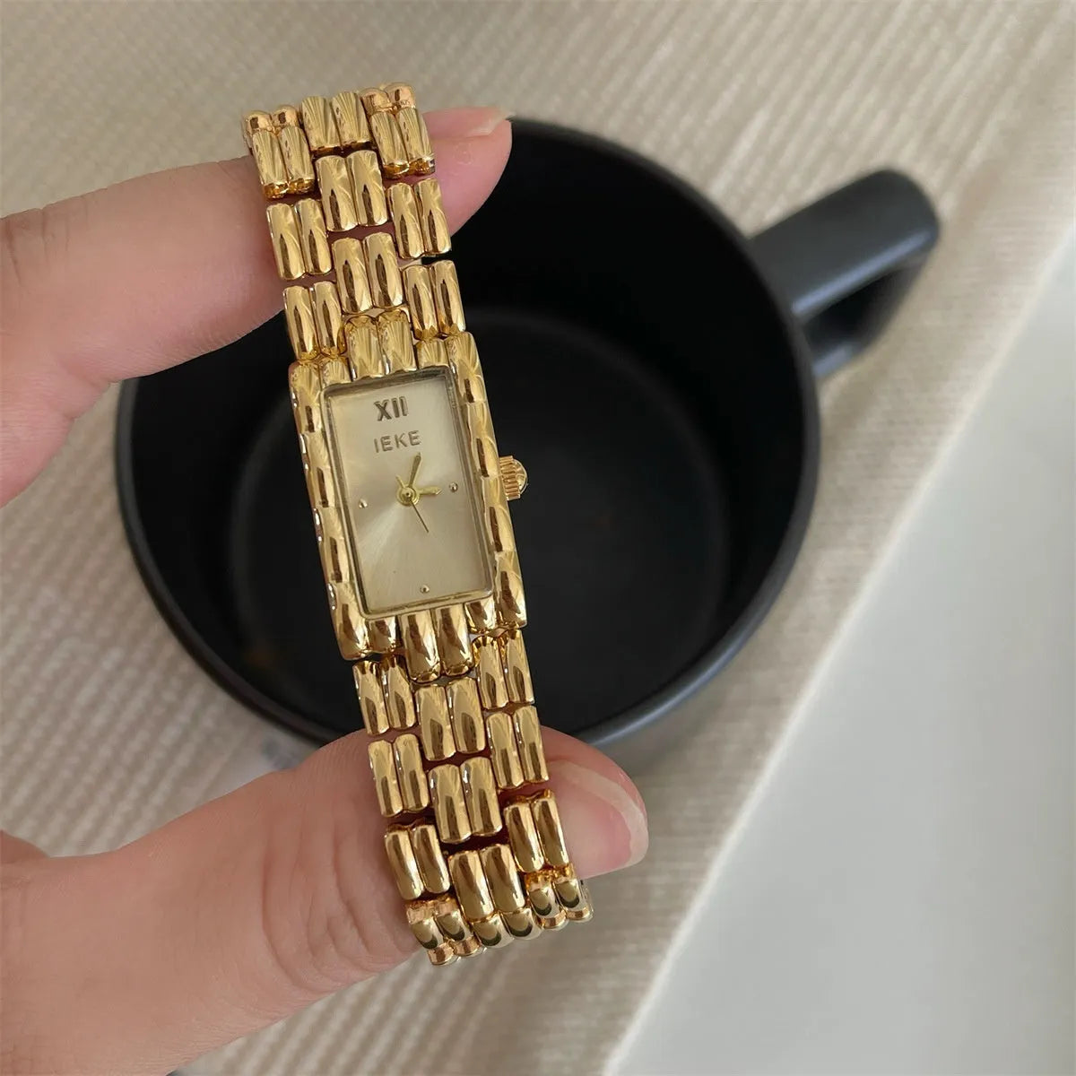 Women's silver and gold bracelet-style watch with a small 15mm dial and butterfly clasp.