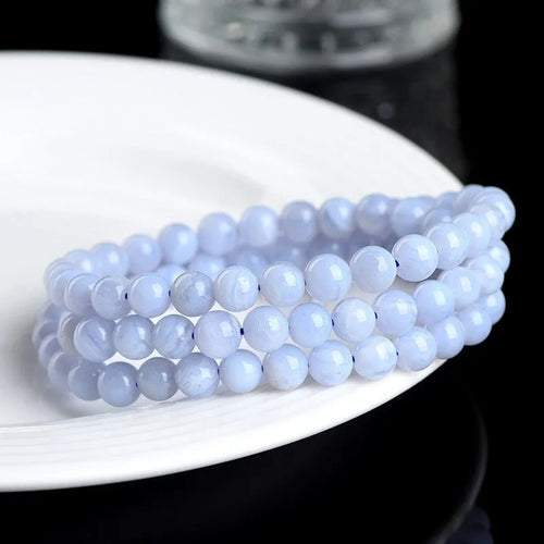 Blue agate bracelet with multi-circle pattern and scattered striped beads on a wrist.