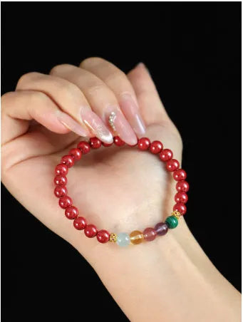 Purple gold cinnabar crystal bead bracelet on wrist showing handcrafted string construction
