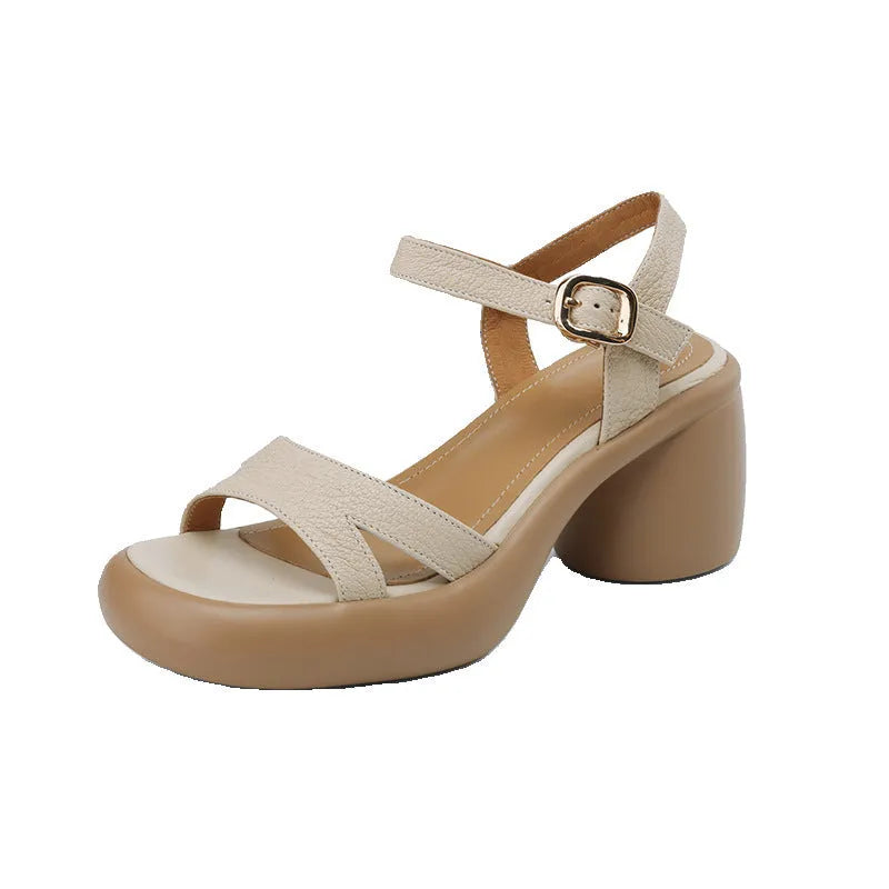 Women's beige open toe platform sandals with a round toe design and a thick rubber sole on a wooden surface.