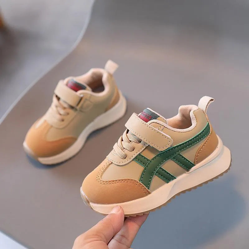 Children's white velcro sneakers with synthetic leather upper and rubber sole on a neutral background.