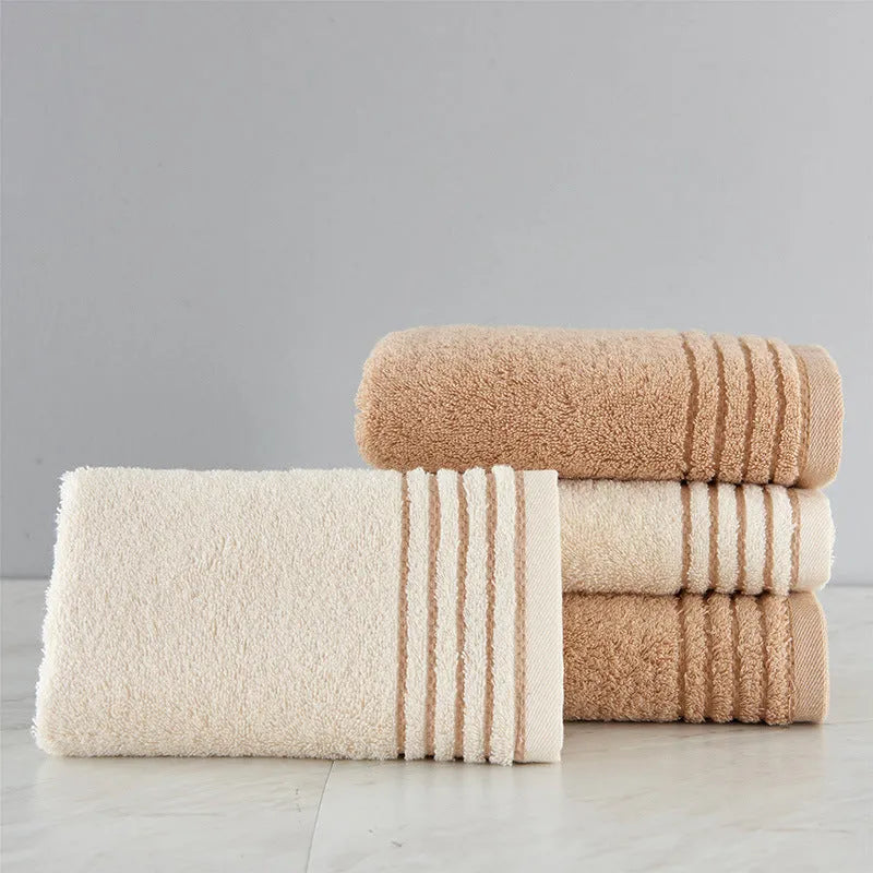 Set of three cotton towels in beige and brown colours, showing small, medium, and large sizes.