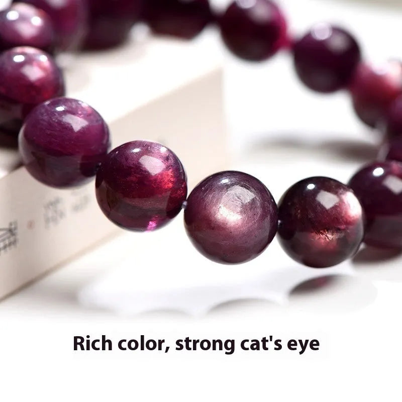 Natural purple lepidolite crystal round bead bracelet with adjustable cord on a wooden surface.
