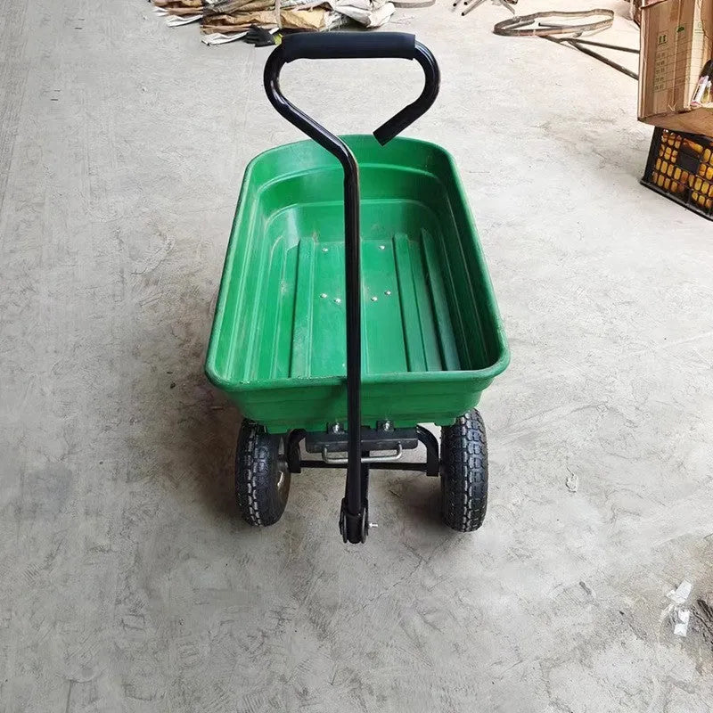 Green four-wheel plastic dump truck with a large cargo bed, shown on grass.