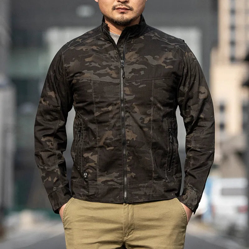 Man wearing a brown tactical jacket with multiple pockets and a plaid camouflage pattern, suitable for outdoor use.