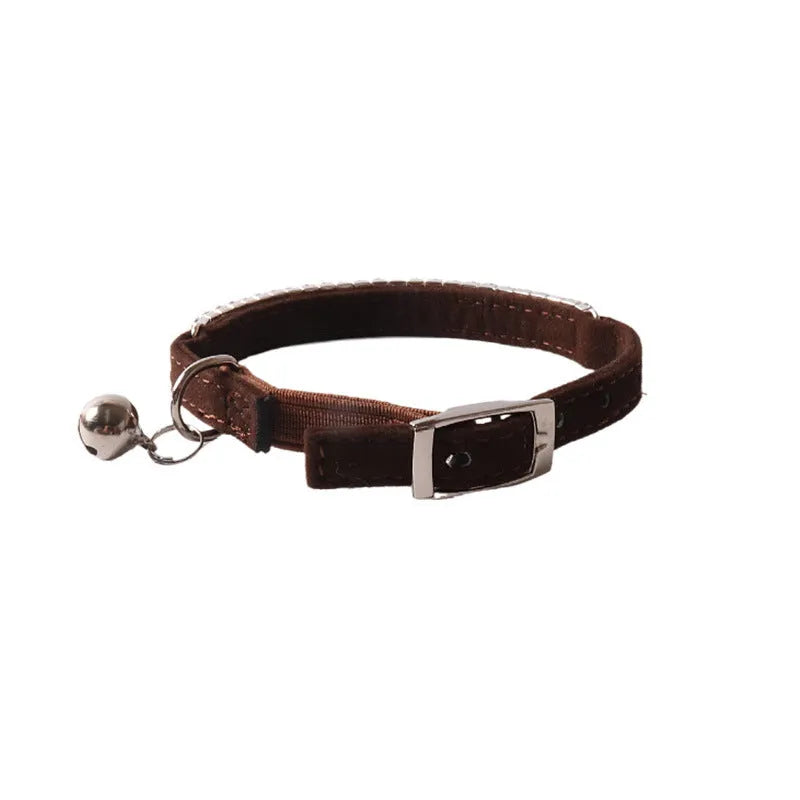 Soft pink flocked cat collar with an elastic section and plastic buckle on a grey background.