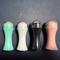 A small portable volcanic stone roller for absorbing facial oil, shown in various colours on a neutral background.