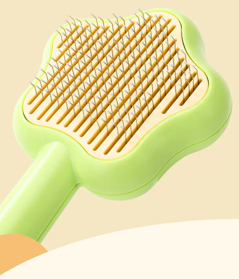 Green self-cleaning stainless steel magic wand cat comb on a white background.