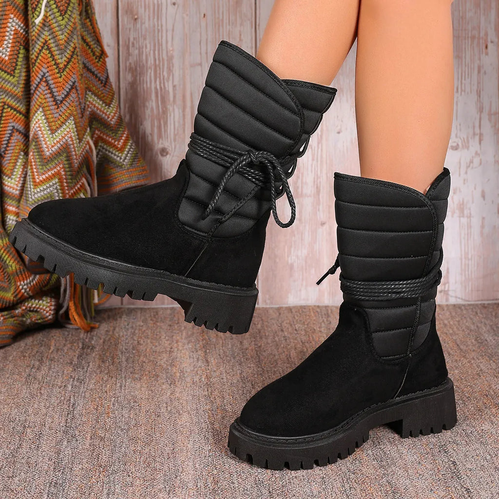 Women's black suede high-top snow boots with chunky rubber sole and lace-up design.