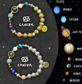 Set of twelve natural stone beaded bracelets laid out, each tagged with a different zodiac sign symbol.