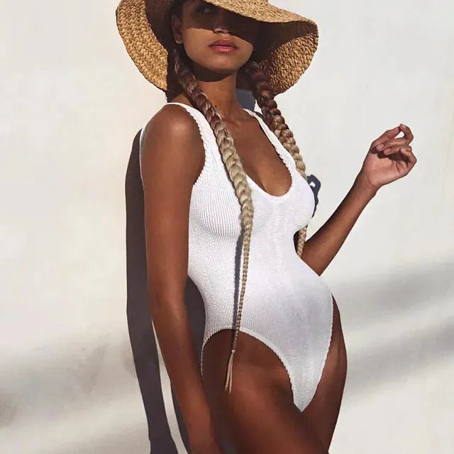 Solid colour one-piece swimsuit with textured seersucker fabric in a backless, sleeveless design.