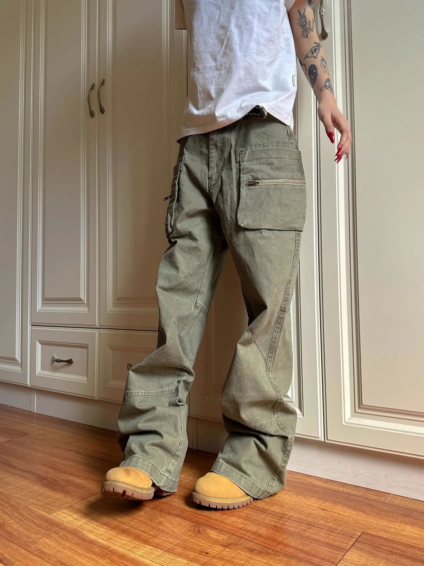 Green and black double zipper casual cotton pants with an elasticated waistband on a hanger.