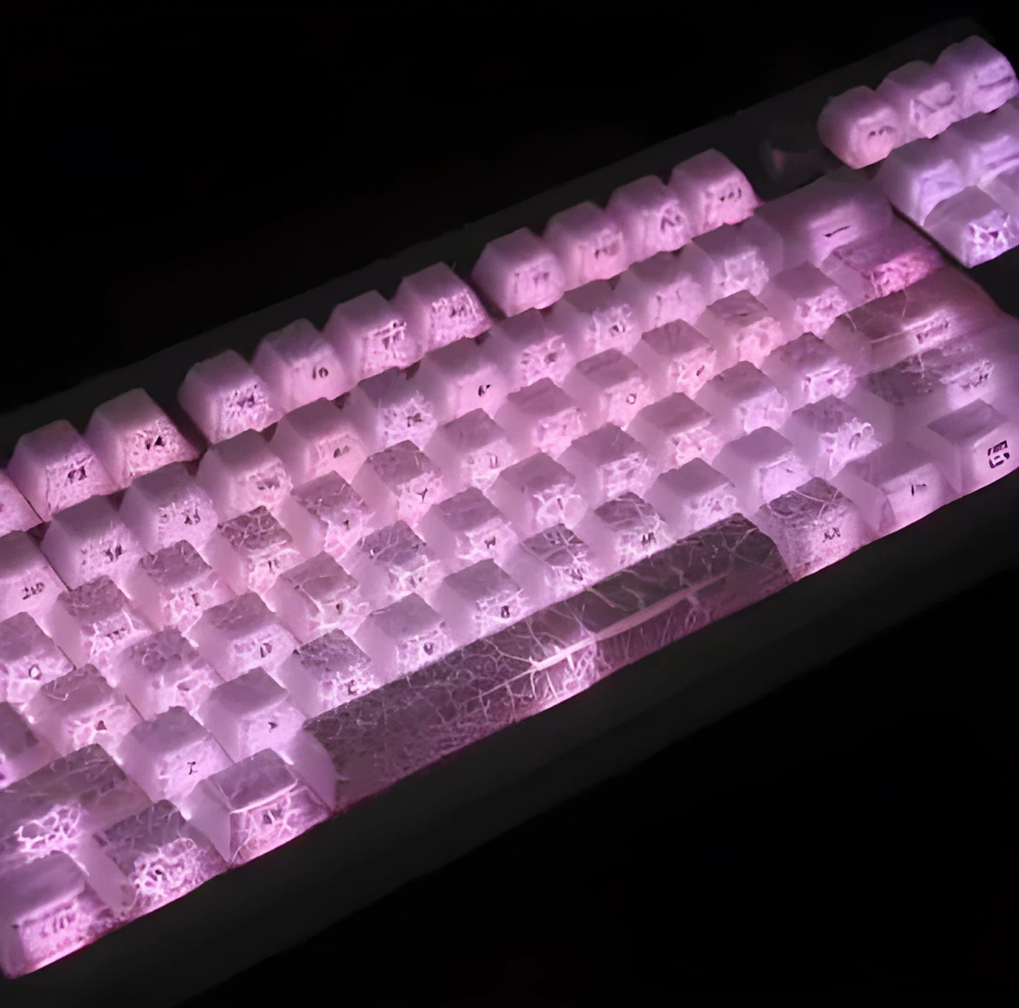 Transparent mechanical keyboard keycaps with white double-stitched lettering on clear PC material