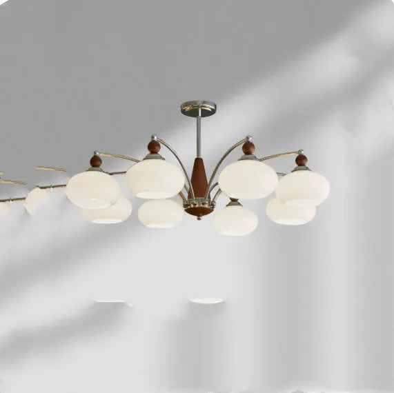 Traditional persimmon glass chandelier with multiple chrome arms and white glass lampshades hanging from a ceiling.