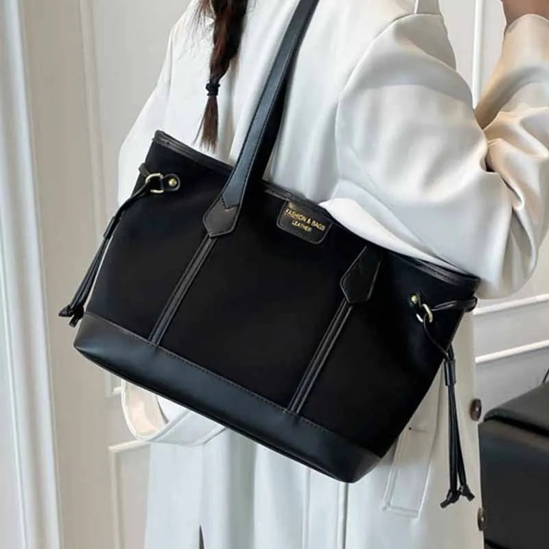 PU leather shoulder bag in black, horizontal square shape with double shoulder straps and sewing line detailing