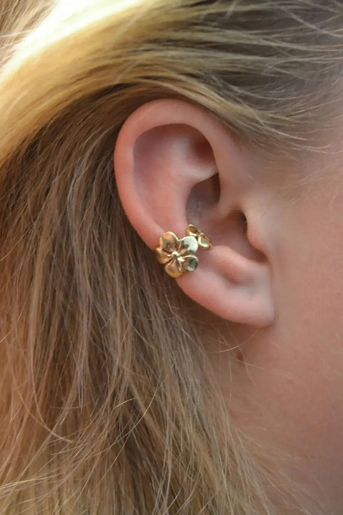 Gold-coloured alloy earrings with starfish and conch designs on a white background.