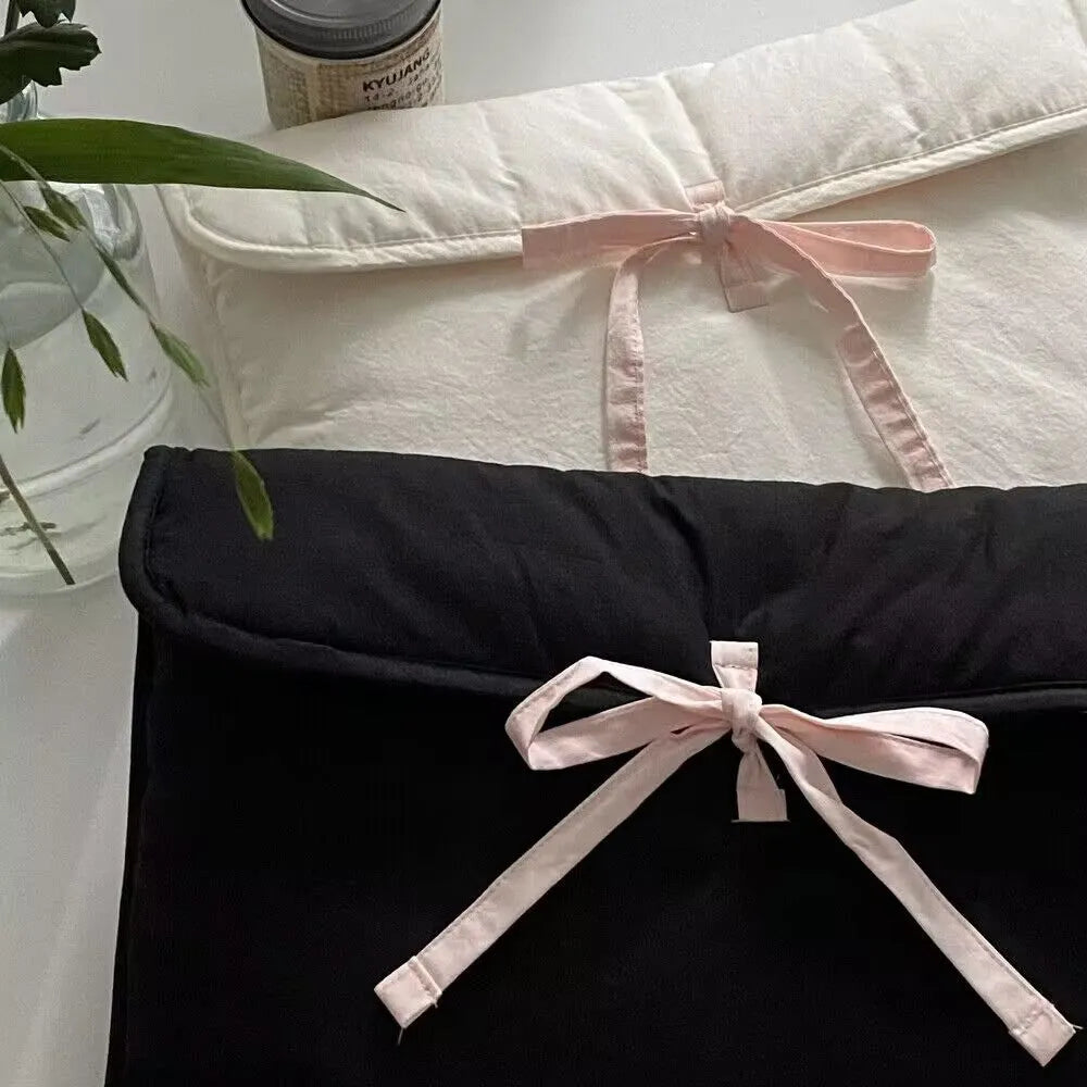 Black and white quilted women's laptop bag with a ballet bow, showing striped pattern and laptop compartment.