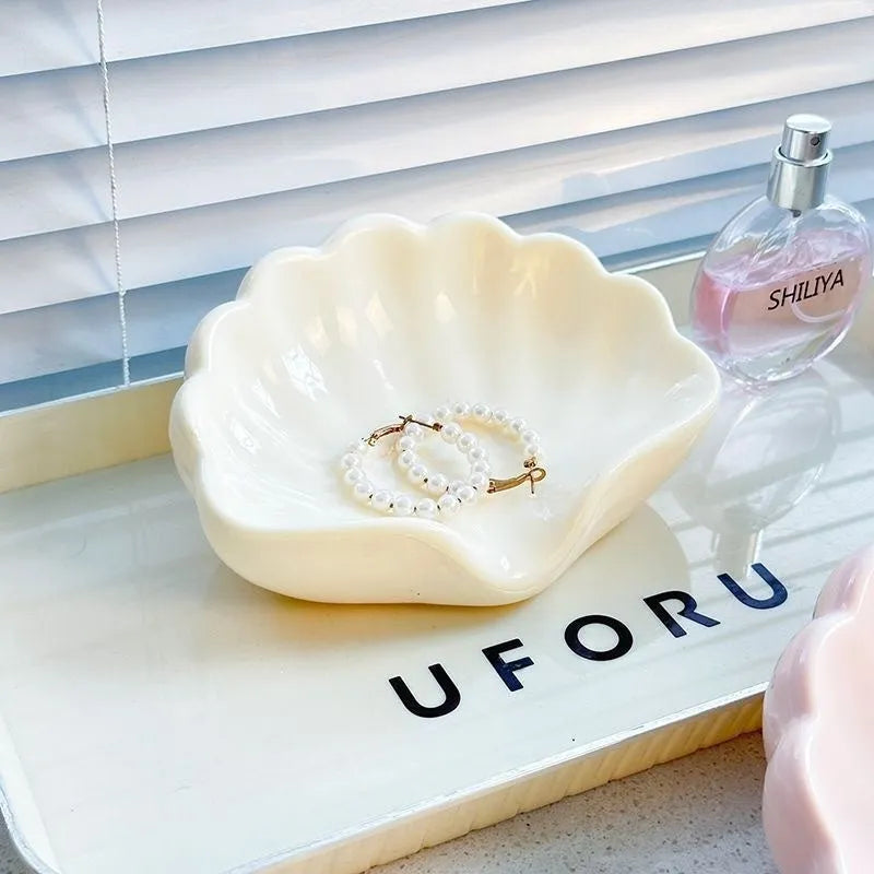 White plastic shell-shaped soap dish for bathroom vanity storage.