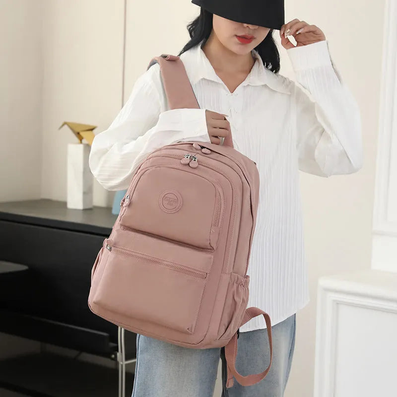 Women's waterproof nylon travel backpack with multi-compartments in rose red colour showing organisational features