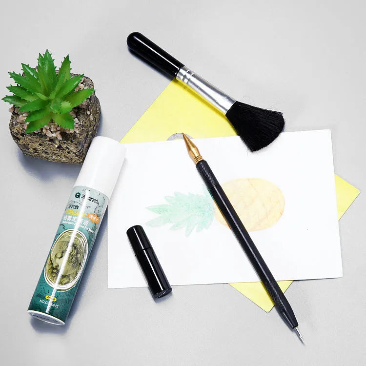 Scratch painting art tool set with healing pen, brushes, and scraper on white card paper.