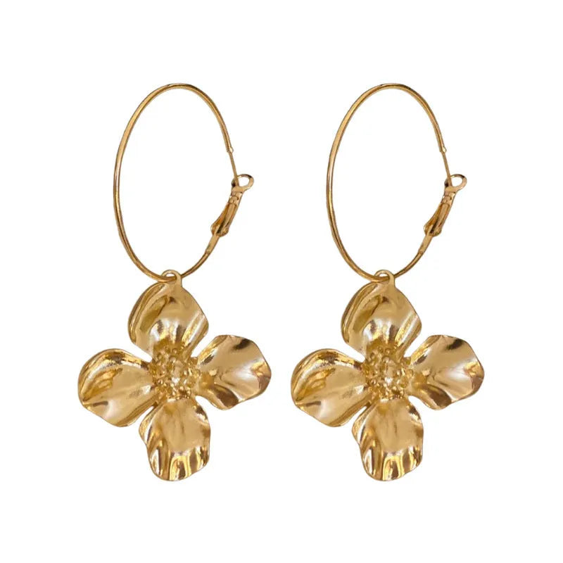 A pair of vintage-style metal flower earrings with a silver needle and geometric design in a gold or silver colour.