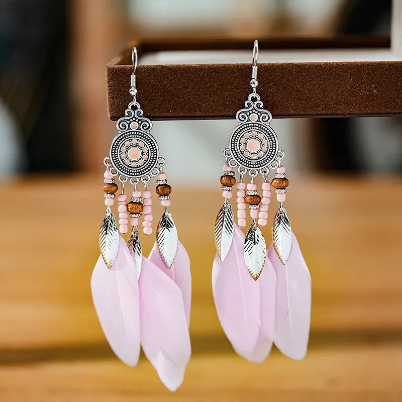 Round drop feather earrings in alloy with electroplated finish showing leaf shape and pattern details