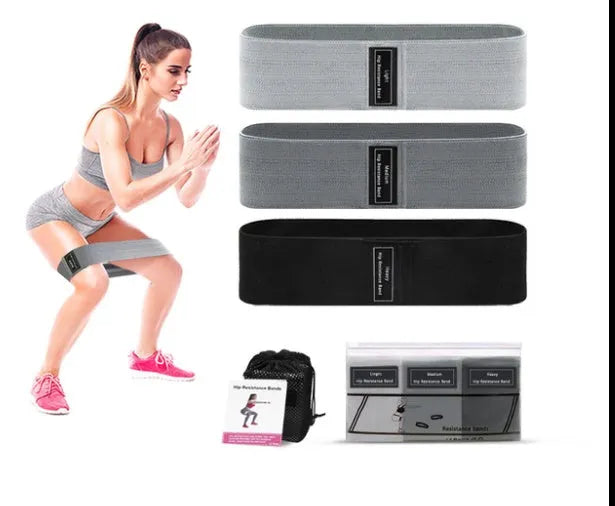 Set of three coloured fabric resistance bands and a net storage bag for home fitness.