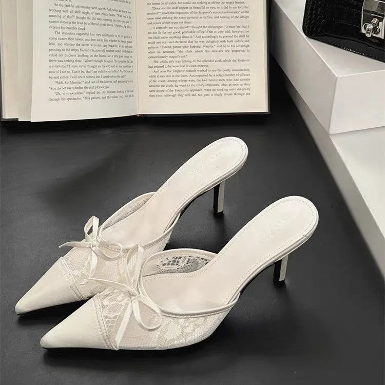 Women's light brown lace mesh high heels with pointed toe and a black bowknot decoration.