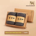 Set of four pairs of solid-colour merino wool socks with reinforced heel and toe on a wooden surface.
