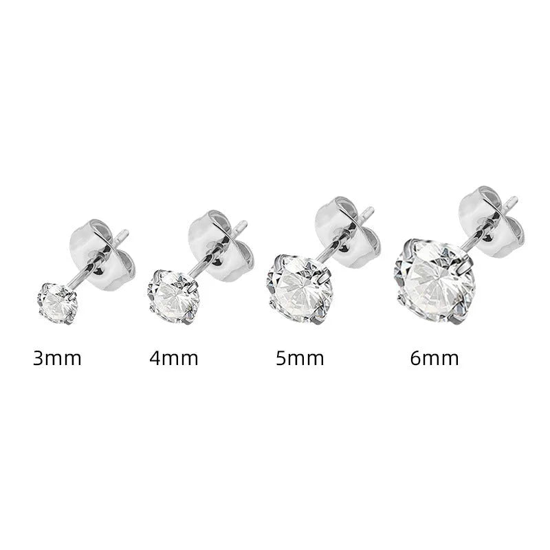 Simple geometric stud earrings with zircon stone in gold or steel colour on grey background.