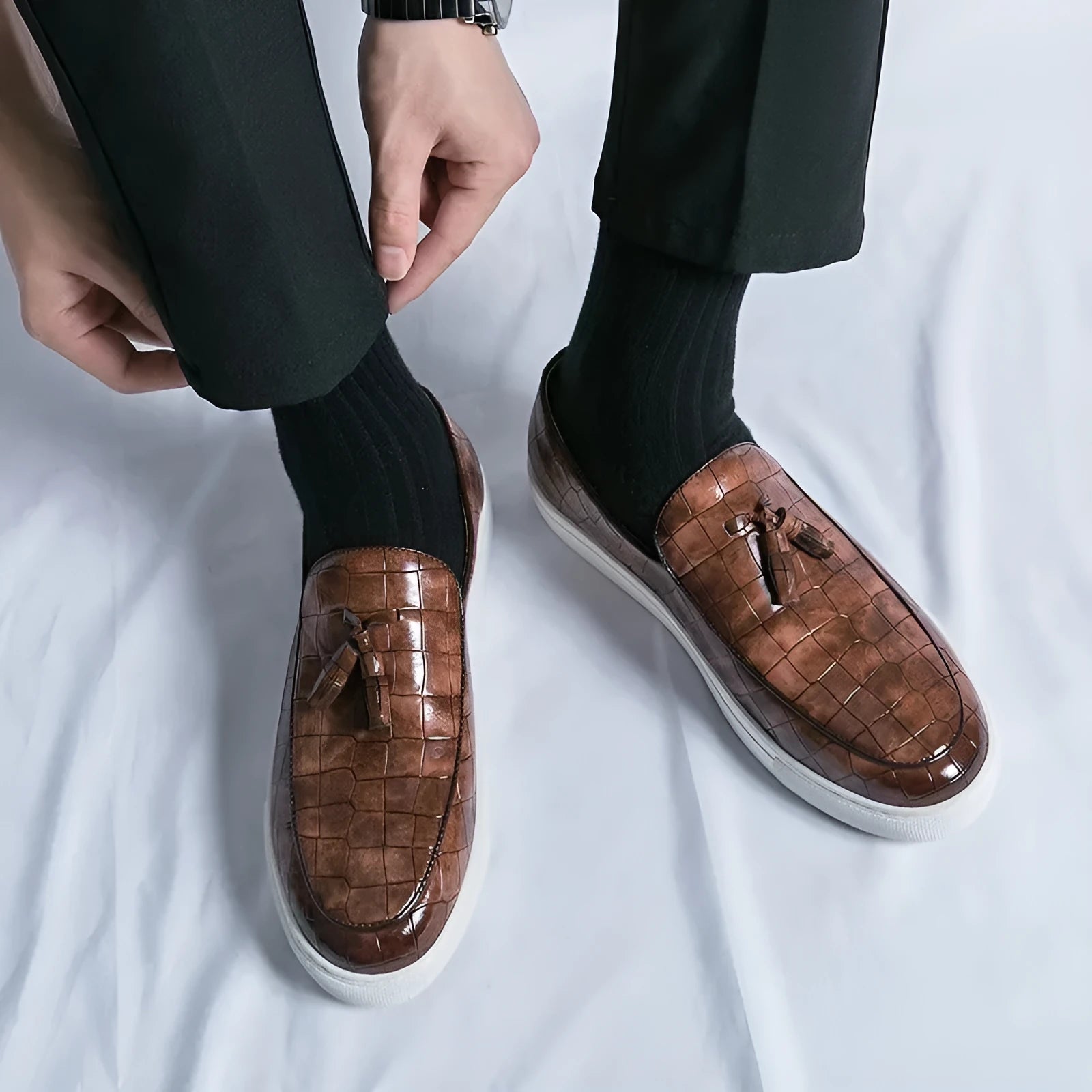 Plus size men's black tassel sneakers with round toe and oversleeve design on a rubber sole.
