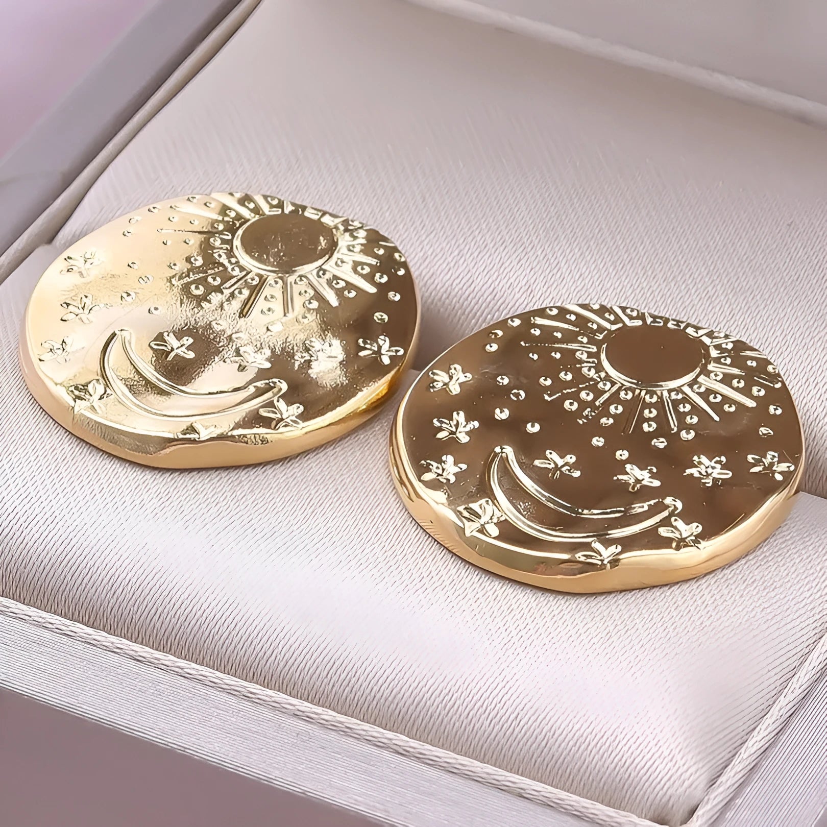 A pair of geometric-shaped stainless steel ear studs with a shell detail, shown in gold and silver colour options.