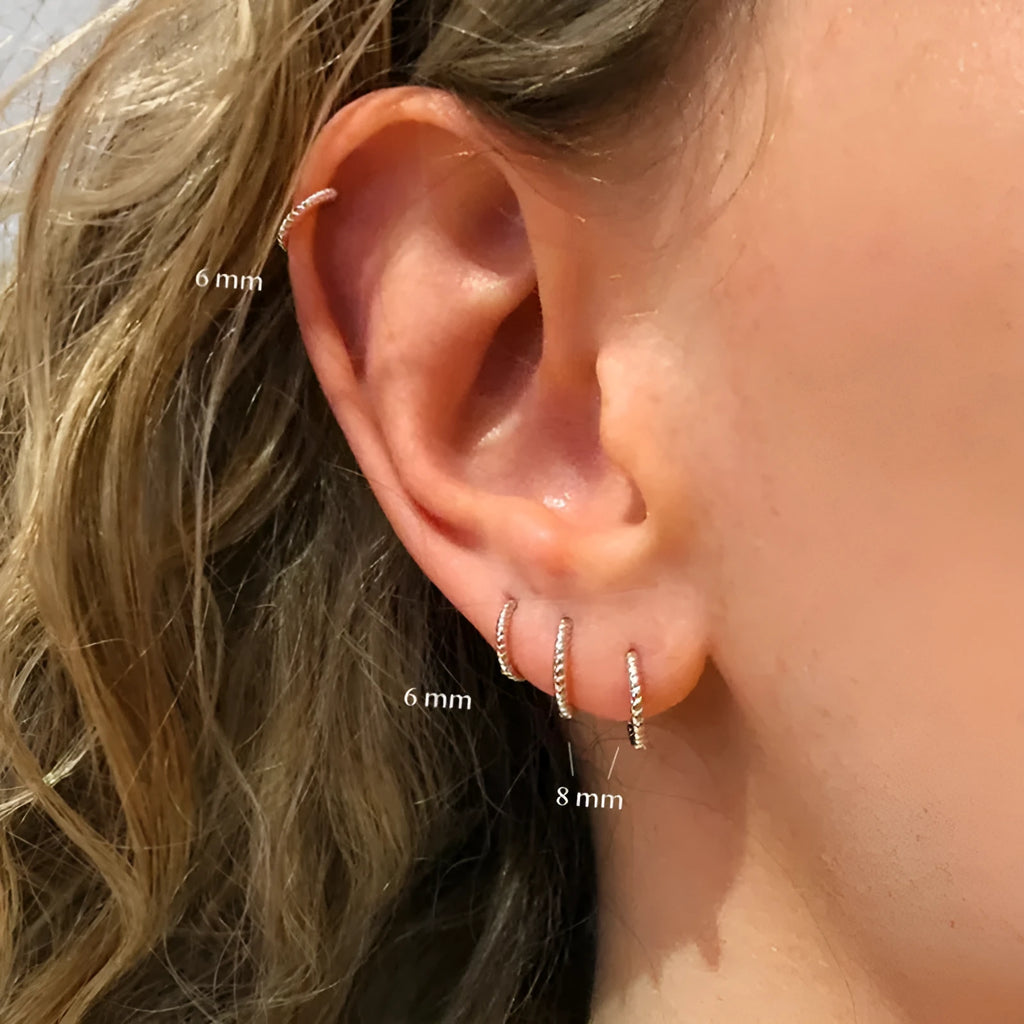 Sterling silver twisted string round hoop earrings in gold colour, showing geometric detail.
