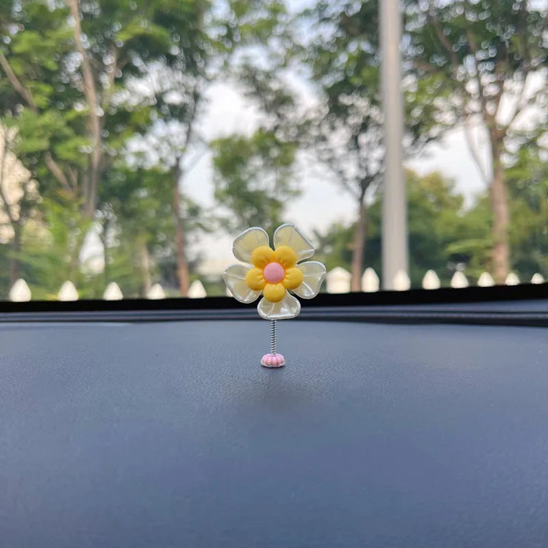 Small colourful plastic swing car decoration for dashboard or mirror.