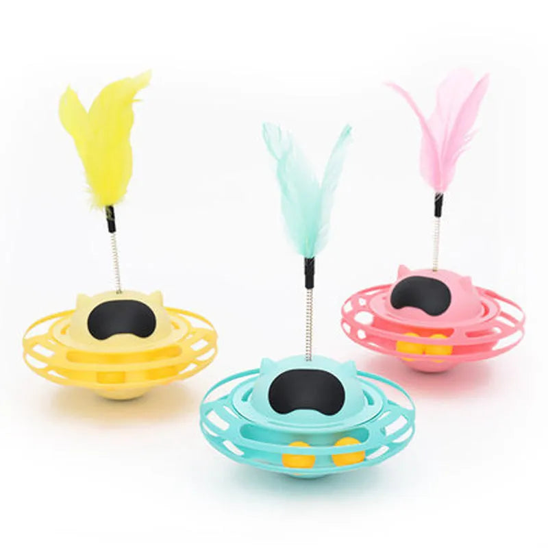 Pink cat tumbler turntable toy with feather attachments on rotation platform