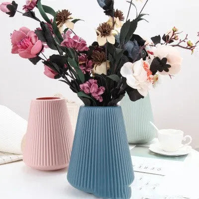 Colourful melamine plastic decorative flower vase, 16 cm by 20 cm, on a desktop.