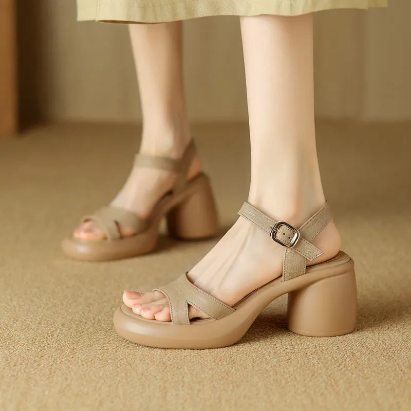 Women's beige open toe platform sandals with a round toe design and a thick rubber sole on a wooden surface.
