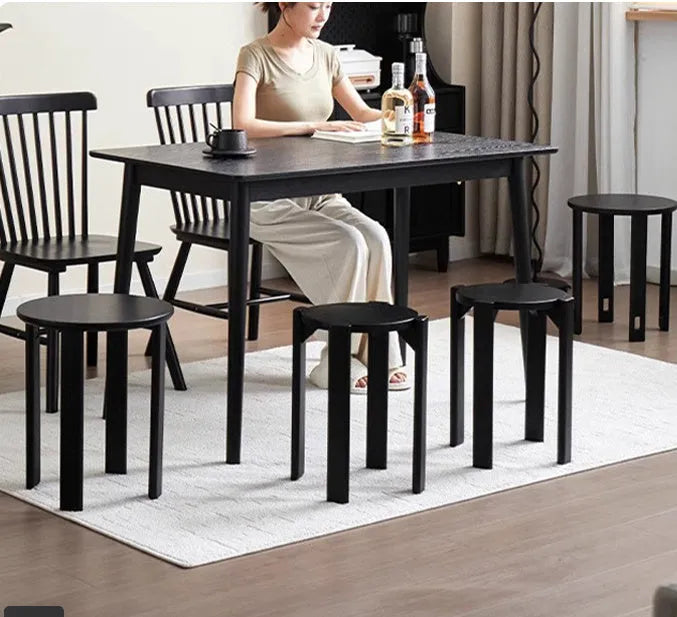 Modern round iron dining stool with stackable design in a wood-tone finish.