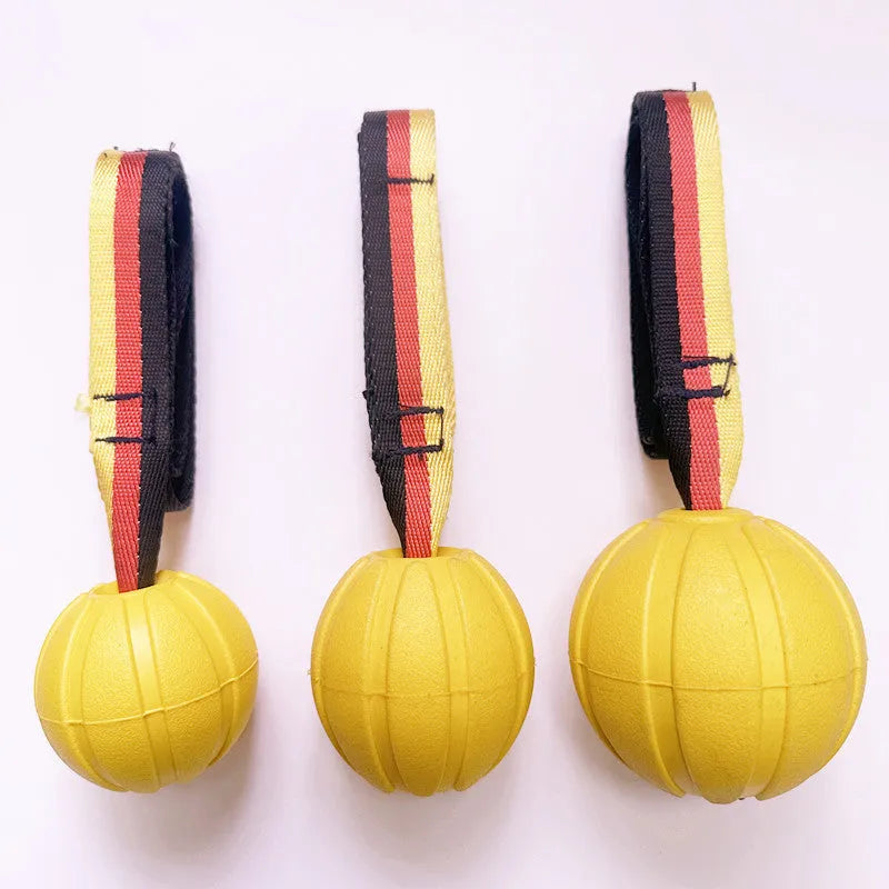 Yellow and camouflage coloured EVA floating dog ball with string in three different sizes on blue background
