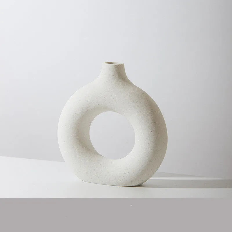 Frosted unglazed porcelain biscuit vase in a simple modern style on a table.