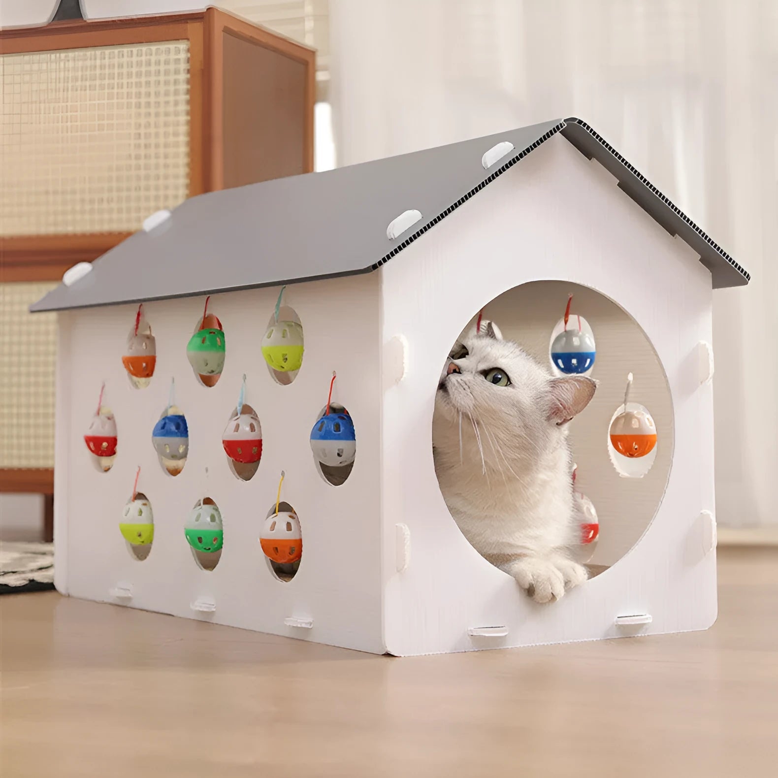Grey integrated cat furniture with sisal scratching panel, plush-lined round nest, and tunnel with dangling bell ball toy.