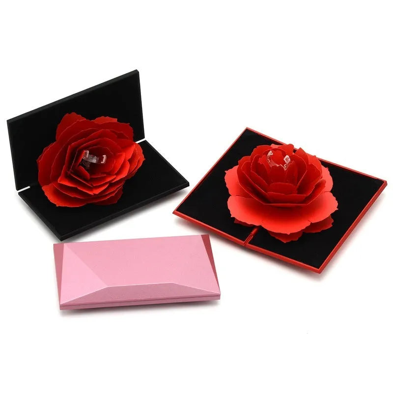 Red heart-shaped plastic ring box with a rose design and rotating 3D love text in the centre.