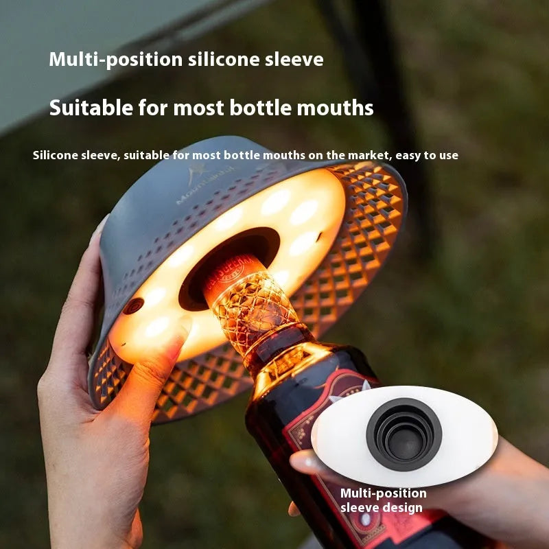 Beige recycled wine bottle camping lantern with USB-C port, showing warm light glow.