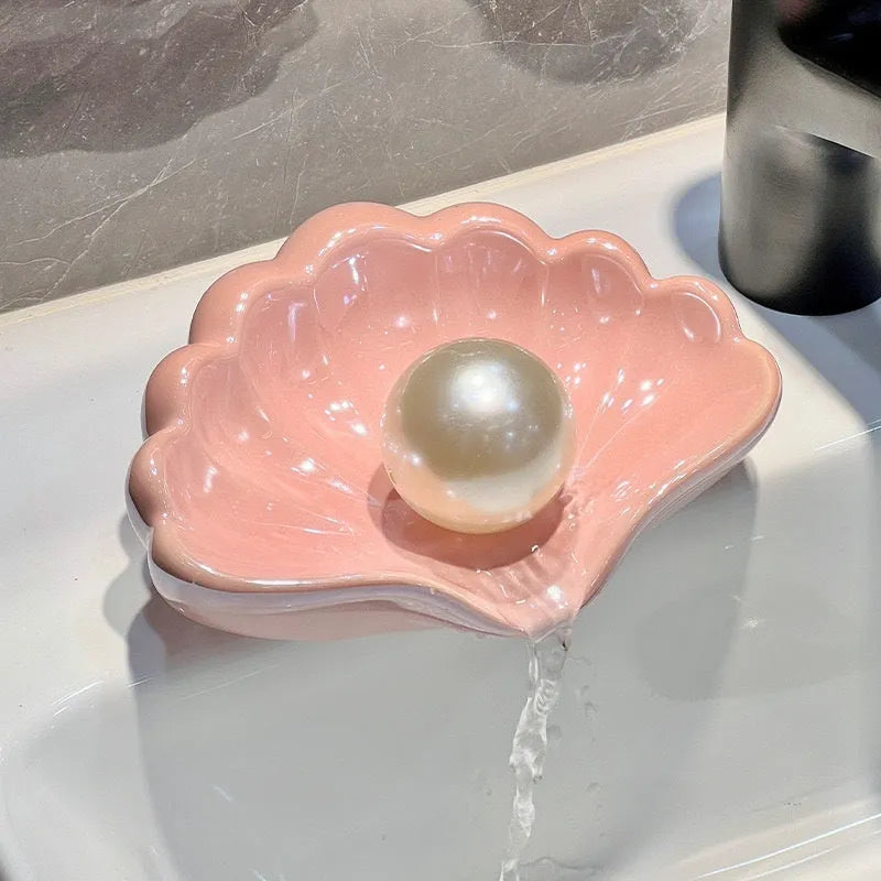 White plastic shell-shaped soap dish for bathroom vanity storage.